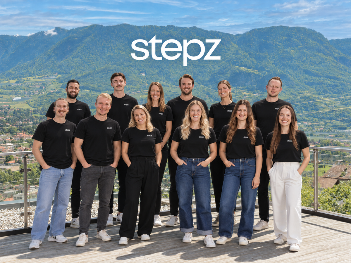 Das stepz Team auf einer Terrasse mit Bergblick.